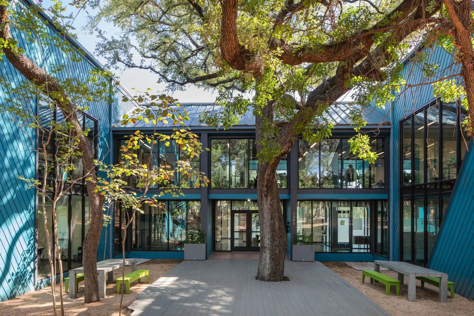 Fachada do campus da Alpha School em Austin, no Texas, com árvores no pátio